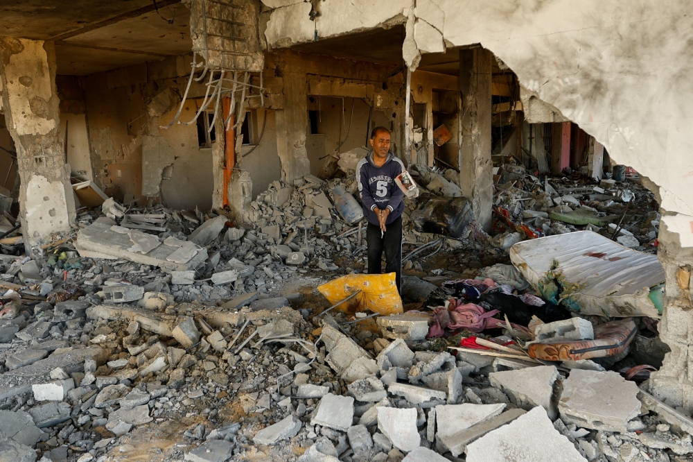A man walks among debris at the site of an Israeli strike on the apartment building, amid the ongoing conflict between Israel and Palestinian Islamist group Hamas, in Khan Younis in the southern Gaza Strip November 18, 2023. — Reuters pic