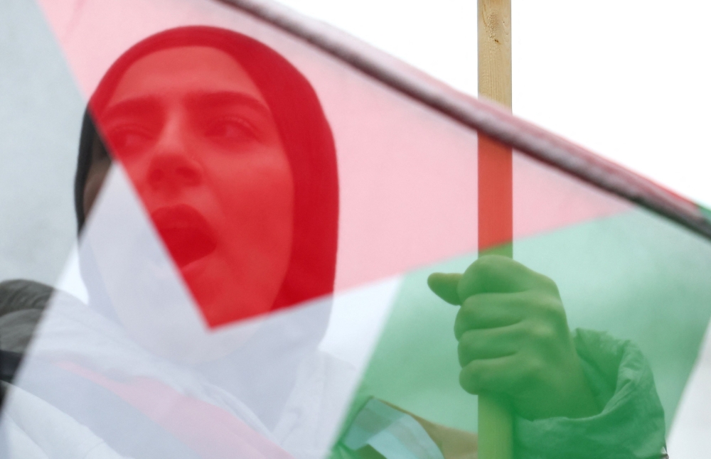 A demonstrator protest in solidarity with Palestinians in Gaza in London. — Reuters pic