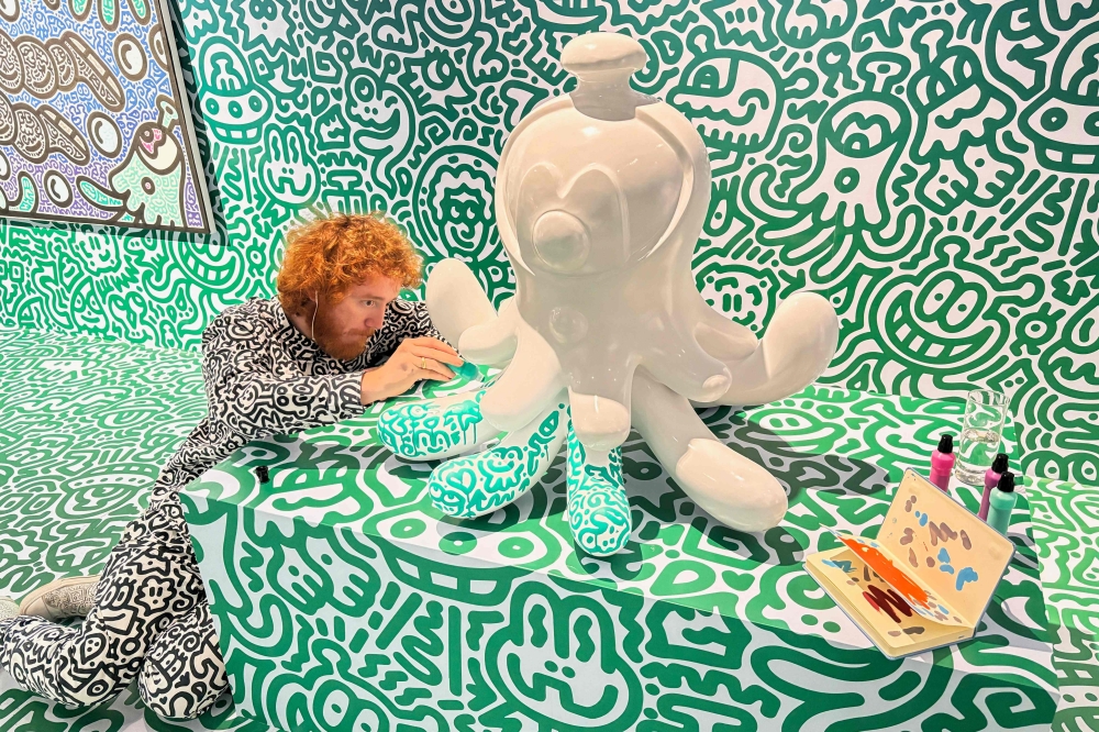 This photo taken on November 16, 2023 shows British artist Sam Cox, better known as Mr Doodle, working on a sculpture named ‘Jellyboggle’ at Pearl Lam Galleries in Hong Kong. — AFP pic