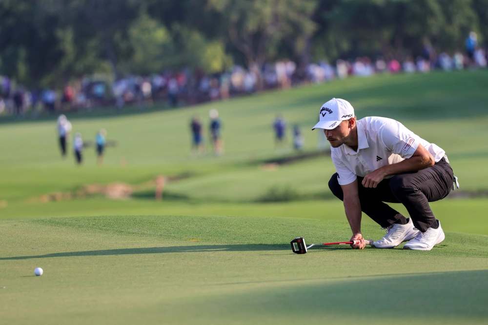 Denmark's Nicolai Hojgaard lines up a putt during the last day of the DP World Tour Championship European Tour golf tournament 2023 at Jumeirah Golf Estates in Dubai on November 19, 2023. — AFP pic