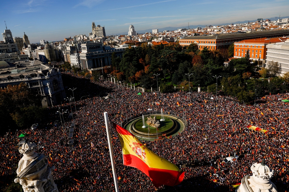 A Spanish flag flies as people take part in a protest after Spain's socialists reached a deal with the Catalan separatist Junts party for government support, which includes amnesties for people involved with Catalonia's failed 2017 independence bid, at Cibeles Square in Madrid, Spain November 18, 2023. — Reuters pic