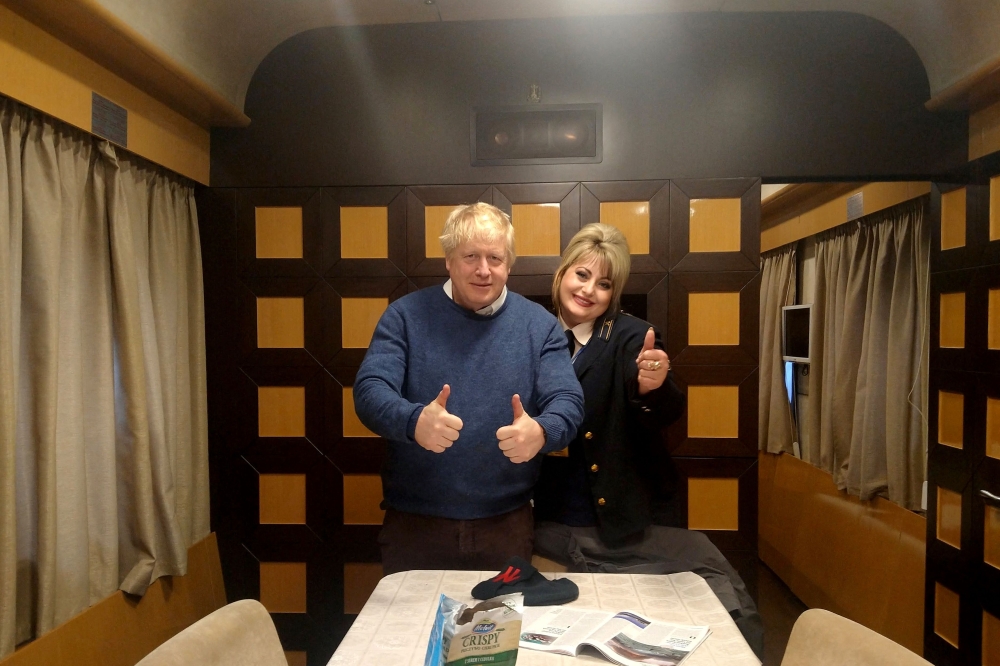 This handout photograph from the courtesy of train hostess Tetyana Kogut taken on April 21, 2022, shows then British prime minister Boris Johnson posing for a picture with Tetyana in a train carriage in Kyiv. — Handout/Courtesy of Tetyana Kogut/AFP pic