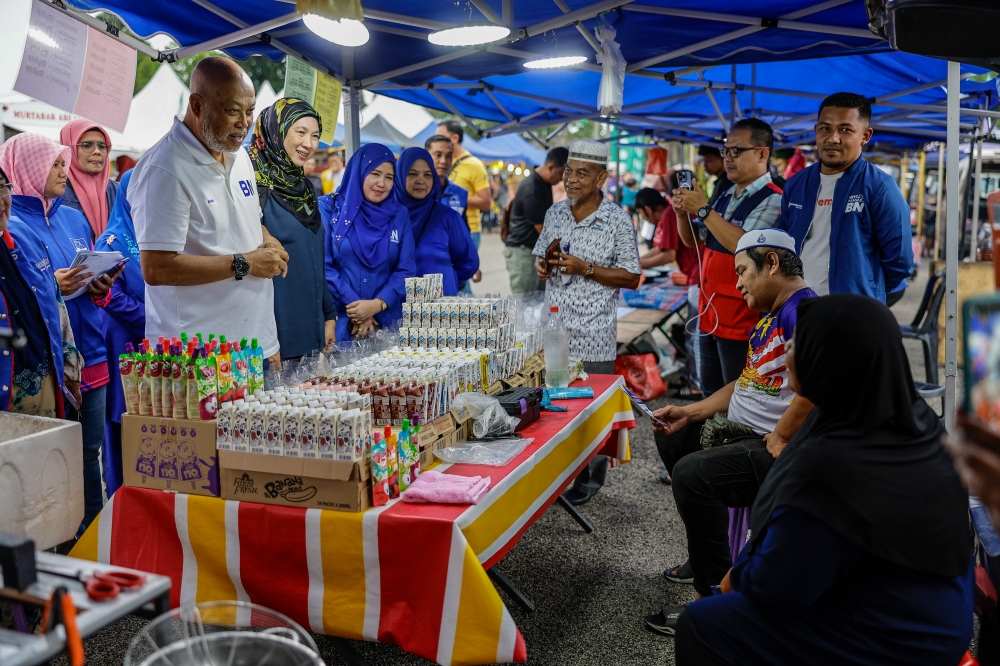 Barisan Nasional candidate Gen (Rtd) Tan Sri Raja Mohamed Affandi Raja Mohamed Noor (front, left) greets vendors during a visit to the Paya Berenjut night market in Kemaman November 21, 2023. — Bernama pic