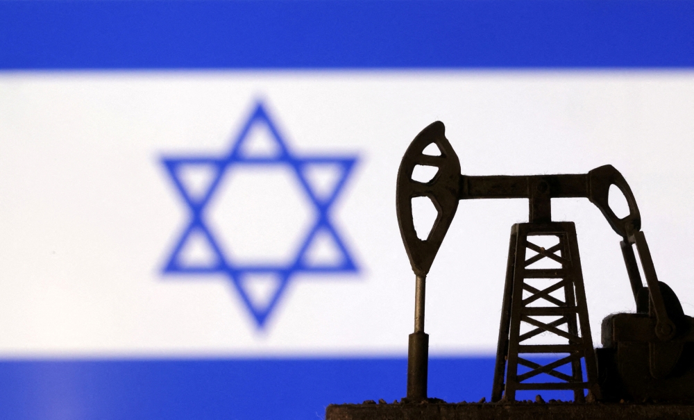 Oil pump jack is seen in front of displayed Israeli flag in this illustration taken October 8, 2023. — Reuters pic