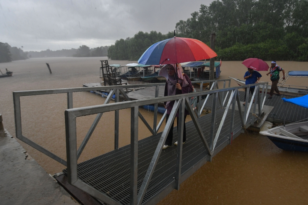 Residents at the Kok Majid jetty during the rainy season in Tumpat, Kelantan, November 20, 2023. — Bernama pic 