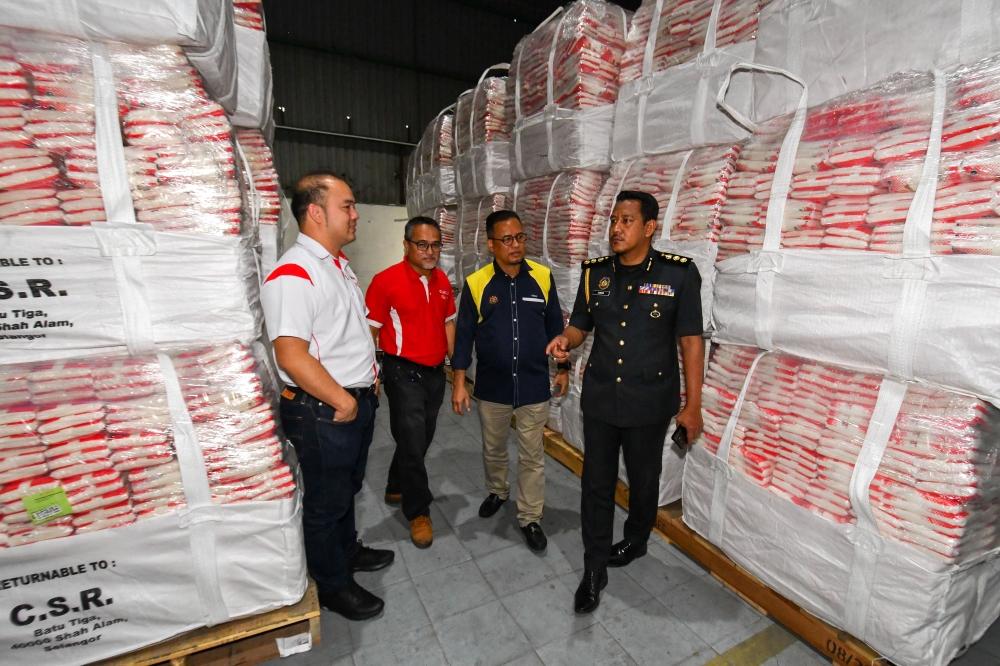 Domestic Trade and Cost of Living director Azman Ismail (2nd right) and other officers look at the sugar supply during an inspection of the distribution chain of basic necessities in Pengkalan Chepa November 22, 2023. — Bernama pic
