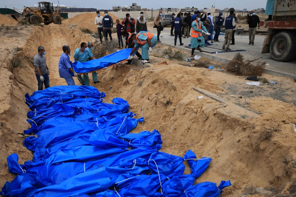 The bodies of dozens of unidentified people were buried yesterday in a mass grave at a cemetery in Khan Yunis, in the southern Gaza Strip. — AFP pic
