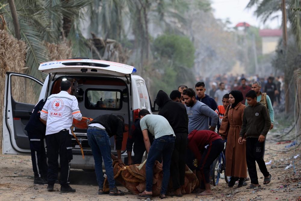 Palestinians rescue a citizen after an Israeli bombing on Khan Yunis. — AFP pic