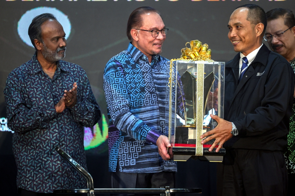 Prime Minister Datuk Seri Anwar Ibrahim hands out the Skilled Person Award to Datuk Shamsuddin Amran at Prime Minister’s Golden Hand Award and Skilled Person Award ceremony at the Shah Alam Convention Centre, November 23, 2023. With him is Human Resources Minister V. Sivakumar. — Bernama pic  
