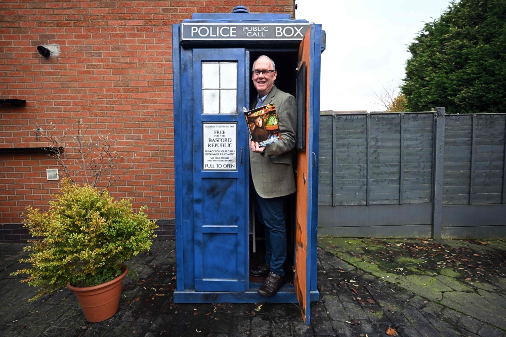 Dr Who fan Tony Jordan poses for a photograph with his Tardis in the garden of his home in Cannock, central England on November 21, 2023.— AFP pic