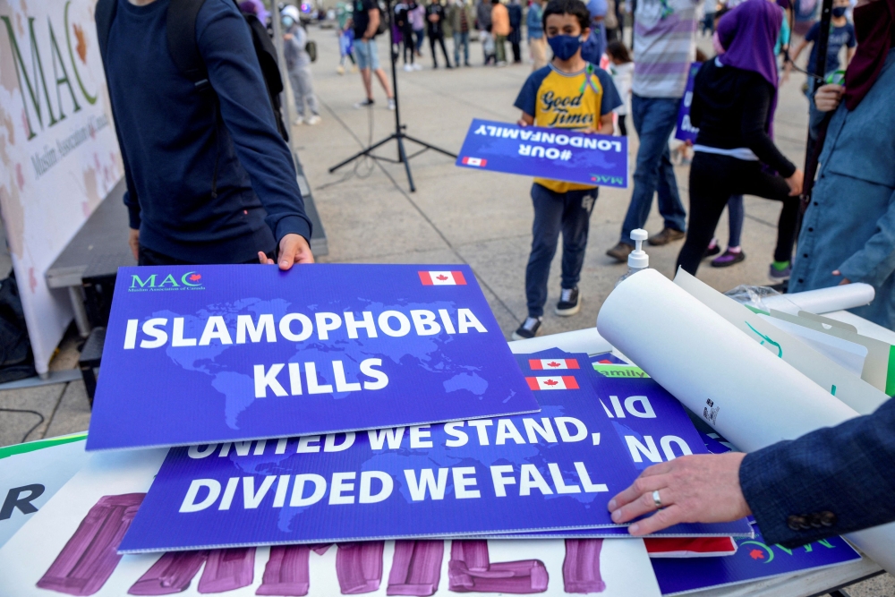 Attendees return signs after a rally to highlight Islamophobia, sponsored by the Muslim Association of Canada, including the June 6 in London, Ontario attack which killed a Muslim family in what police describe as a hate-motivated crime, in Toronto, Ontario, Canada June 18, 2021. — Reuters pic