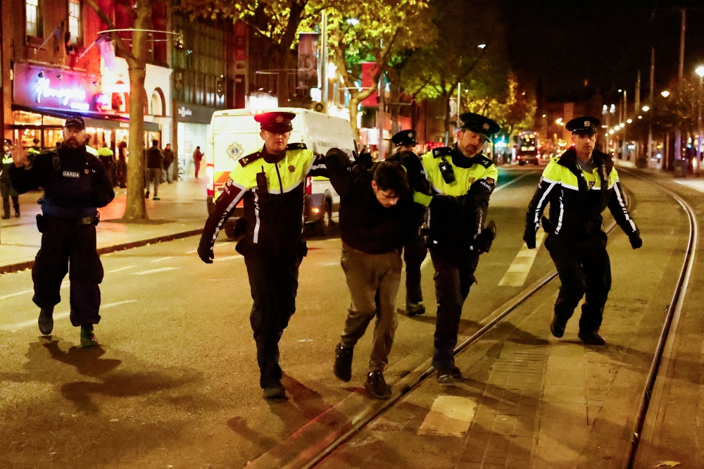 Members of the Garda Public Order Unit detain a man, following a riot in the aftermath of a school stabbing that left several children and adults injured on O'Connell Street, in Dublin, Ireland November 24, 2023. ― Reuters pic