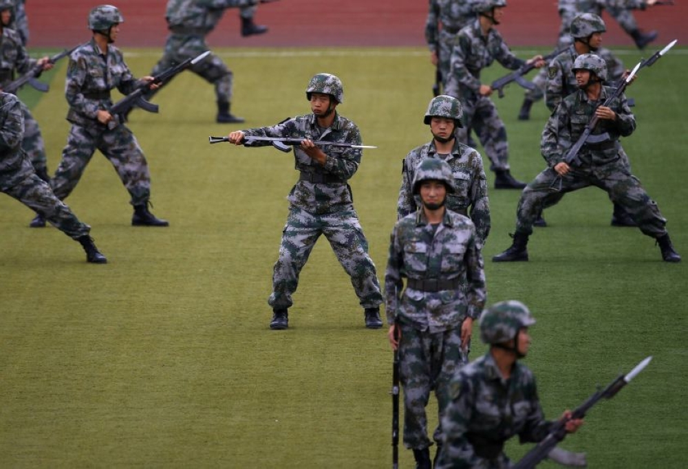 File photo of People's Liberation Army (PLA) soldiers practise with guns in a drill during an organised media tour at a PLA engineering academy in Beijing July 22, 2014. - Reuters pic