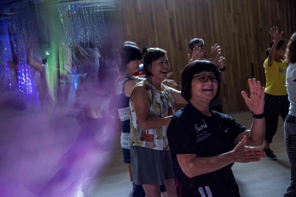 This picture taken on July 31, 2023 shows people taking part in an afternoon disco at a community hall in Hong Kong. — AFP pic