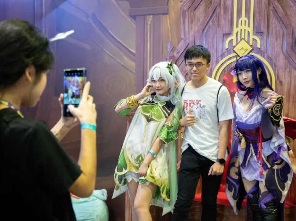 A man posing for photos with cosplayers at Anime Festival Asia November 26, 2023. — TODAY pic