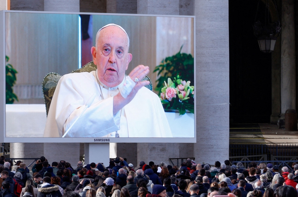 Pope Francis blesses faithful as he appears on a screen in St. Peter's Square, while leading the Angelus prayer from Santa Marta chapel at the Vatican, November 26, 2023. — Reuters pic