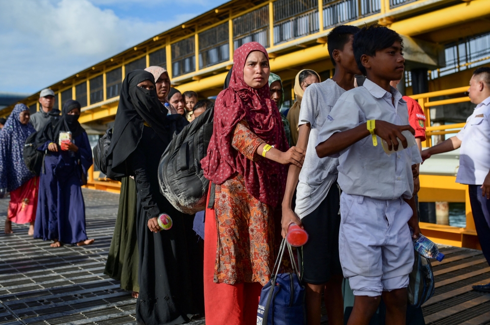 Rohingya Muslims walk in a line as they are being transported to a temporary shelter, following their arrival in Sabang, Aceh province, Indonesia, November 22, 2023. — Reuters pic