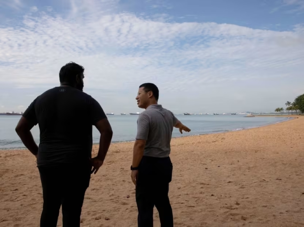 National Development Minister Desmond Lee (right) at East Coast Park on November 28, 2023, looking at the proposed location for ‘Long Island’, a large area of reclaimed land that is being proposed for the future. — TODAY pic