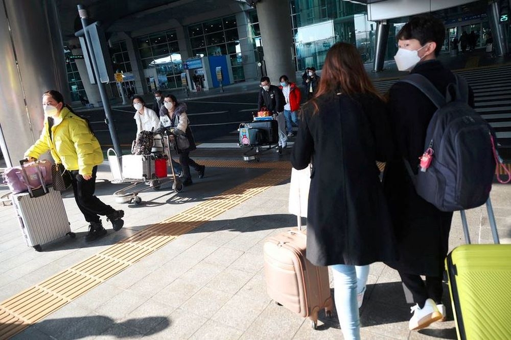 A South Korean couple walks past a group of Chinese tourists as they head for coronavirus disease (Covid-19) testing centre upon their arrival at the Incheon International Airport in Incheon, South Korea January 4, 2023. — Reuters pic