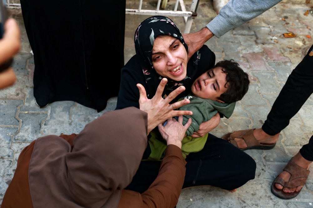 A woman holding a child mourns her baby girl killed in an Israeli strike in Rafah in the southern Gaza Strip, as she waits to receive the body for burial in the courtyard of the al-Najjar hospital on December 1, 2023, after battles resumed between Israel and the Hamas movement. — AFP pic