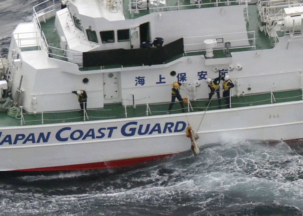 Japan Coast Guard members collect a floating object at the site where a US military aircraft V-22 Osprey crashed into the sea off Yakushima Island, Kagoshima prefecture November 30, 2023, in this photo taken by Kyodo. — Kyodo pic via Reuters