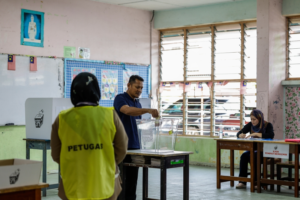 A voter casts his ballot at a polling station in Chukai December 2, 2023. ― Bernama pic