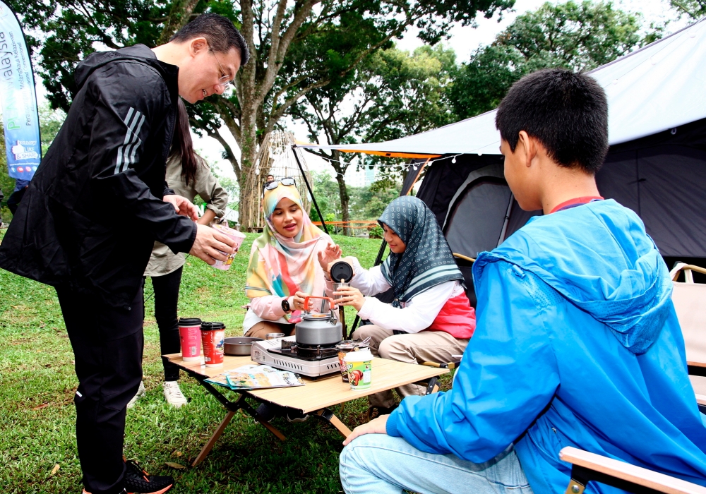 Local Government Development Minister (left) speaks to Nen Farahana Ahmad Fooad’s (3rd right) family during the launch of Campsite Planning Guidelines at Taman DR Seenivasagam in Ipoh December 2, 2023. — Bernama pic