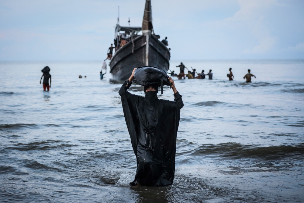 A newly arrived Rohingya refugee walks to the beach after the local community decided to temporarily allow them to land for water and food in Ulee Madon, Aceh province November 16, 2023. The UN called today for nations to rescue hundreds of Rohingya it said were trapped onboard two unseaworthy vessels adrift in the Andaman Sea. — AFP pic