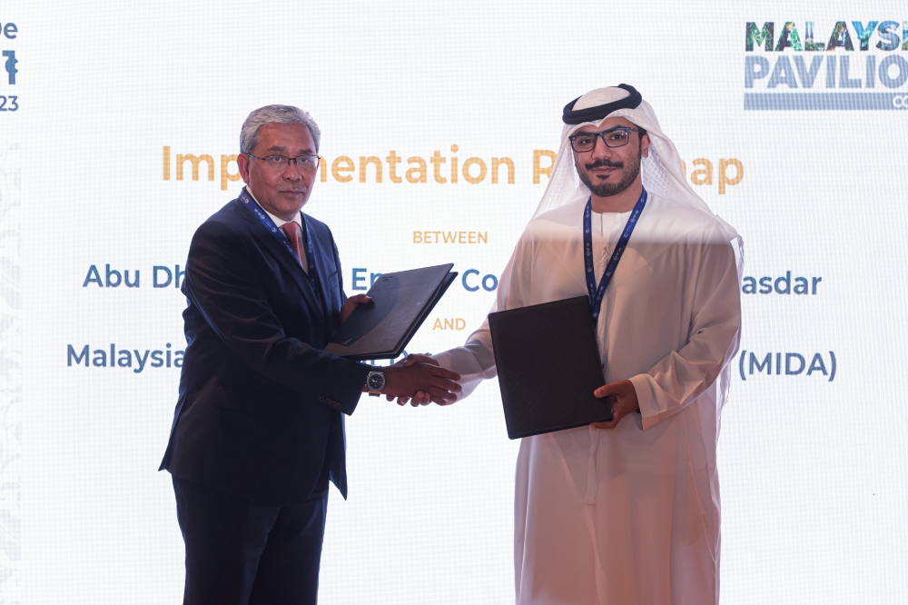 Malaysian Investment Development Authority (Mida) CEO Datuk Arham Abdul Rahman exchanging document with Masdar CEO Mohamed Jameel Al Ramahi on Implementation Roadmap between Abu Dhabi Future Energy Company PJSC - Masdar and Mida during the official launch of Malaysia Pavilion at the 28th Conference of Parties (COP28) to the United Nations Framework Convention on Climate Change (UNFCC), in Dubai Expo City December 1, 2023. — Bernama pic