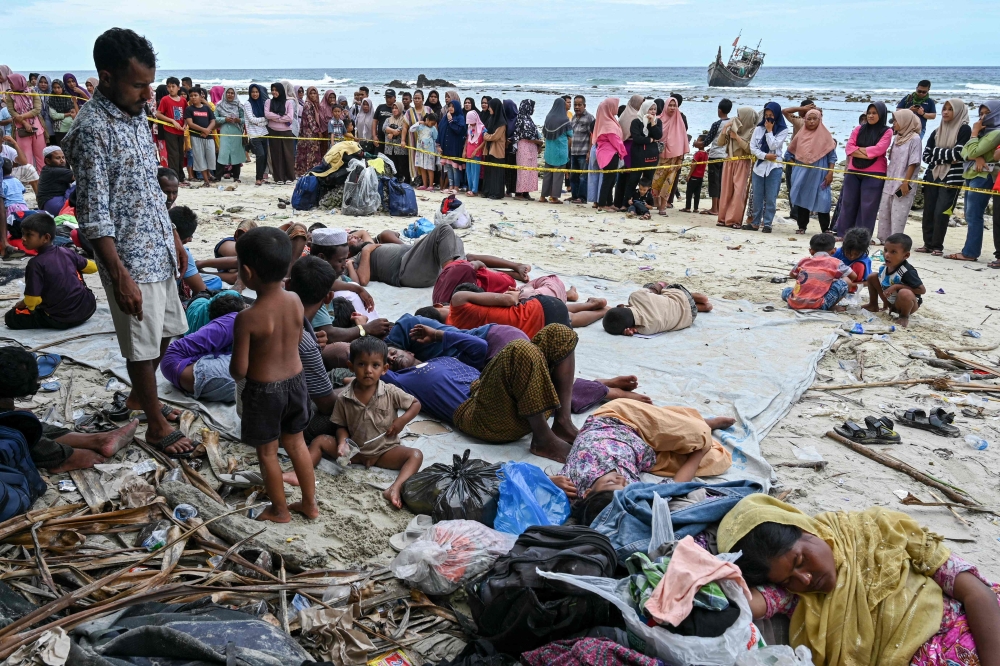 Newly-arrived Rohingya refugees rest at a beach on Sabang island, Aceh province December 2, 2023. — AFP pic