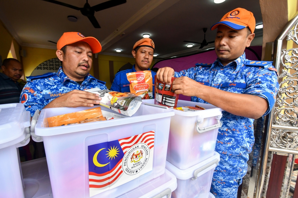 Kelantan APM director Colonel (PA) Mohd Adzhar Mujab (right) and other officers inspect food kits for flood victims at the relief centre at Kampung Padang Licin Mosque in Pasir Mas December 3, 2023. — Bernama pic