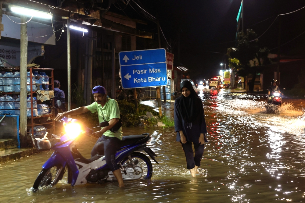 Residents are seen as water levels rise in Sungai Golok, Rantau Panjang December 3, 2023. — Bernama pic