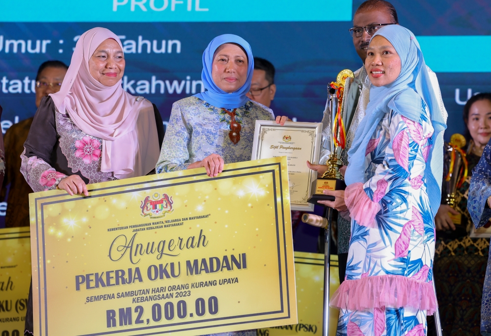 Women, Family and Community Development Minister Datuk Seri Nancy Shukri (2nd left) presents a Madani PwD award to Nor Hidayah Radzli (right) at the launch of the National PwD Day celebration in Kuching December 3, 2023. — Bernama pic 