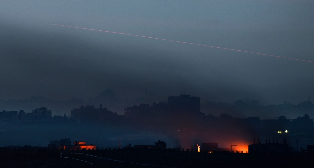 This long time exposure picture taken from southern Israel near the border with the Gaza Strip shows a fire burning and a projectile being fired into the Palestinian territory during battles between Israel and Hamas militants on December 3, 2023. — AFP pic