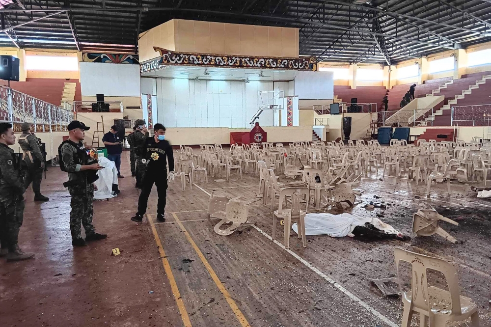 This handout photo taken on December 3, 2023 and released via the Lanao Del Sur Provincial Information Office's Facebook page shows police inspecting the site of a bomb attack inside a gymnasium at Mindanao State University in Marawi. — AFP pic