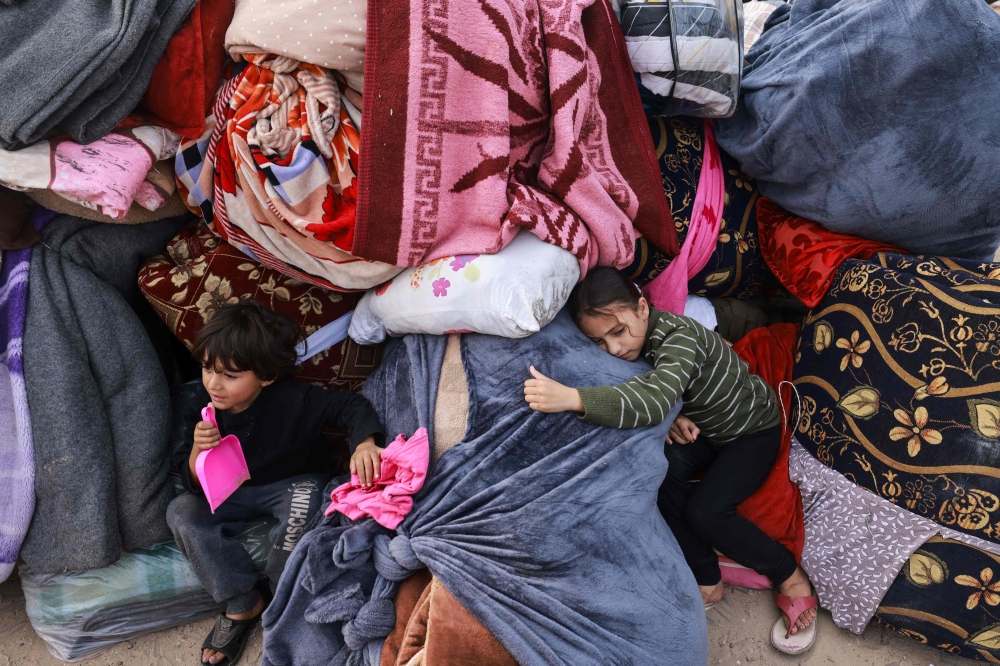 Children rest on blankets as displaced Palestinians fleeing central and southern Gaza set up tents in the new Tall el-Sultan camp west of Rafah in the southern Gaza Strip, on December 3, 2023, amid continuing battles between Israel and the militant group Hamas. — AFP pic