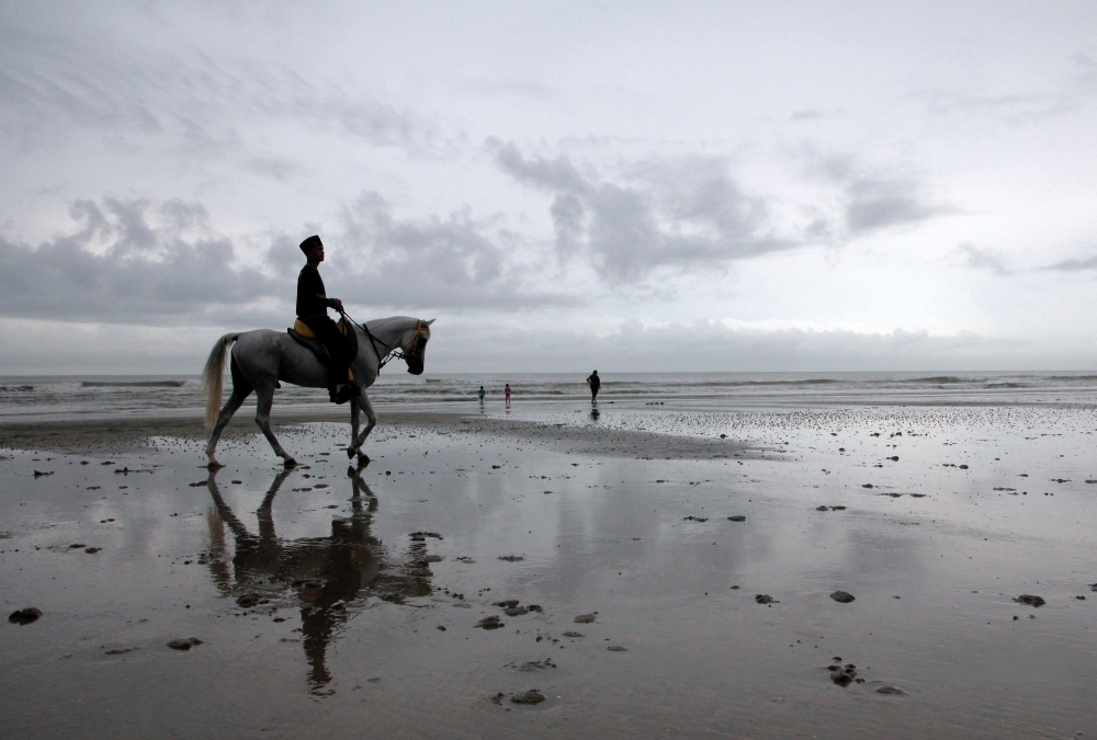 A picture taken at noon shows a teenager riding a horse at Batu Hitam Beach during cloudy weather in Kuantan, Pahang, December 3, 2023. — Bernama pic 