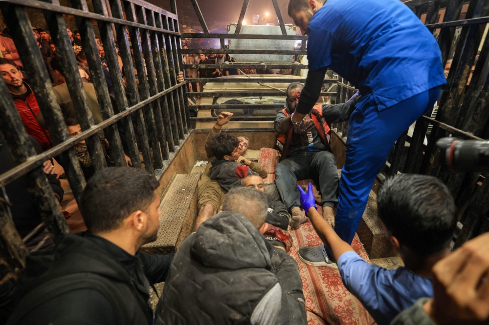 Palestinian paramedics tend to Palestinians wounded during Israeli bombardment, as they arrive at Nasser hospital in Khan Yunis in the southern Gaza Strip on December 4, 2023, amid continuing battles between Israel and the militant group Hamas. — AFP pic