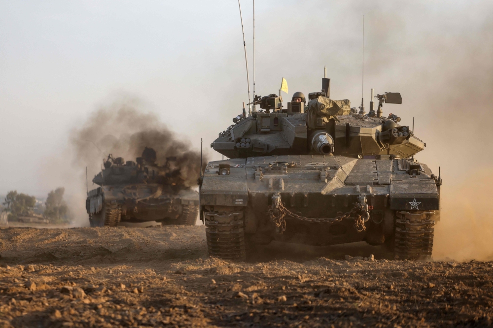 Israeli military tanks roll near the border with the Gaza Strip on December 3, 2023, amid continuing battles between Israel and the Hamas group. — AFP pic