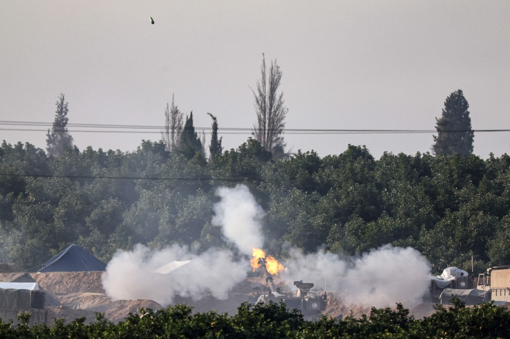 A picture taken from southern Israel near the border with the Gaza Strip on December 4, 2023, shows an Israeli tank firing towards the Palestinian territory amid continuing battles between Israel and the militant group Hamas. — AFP pic