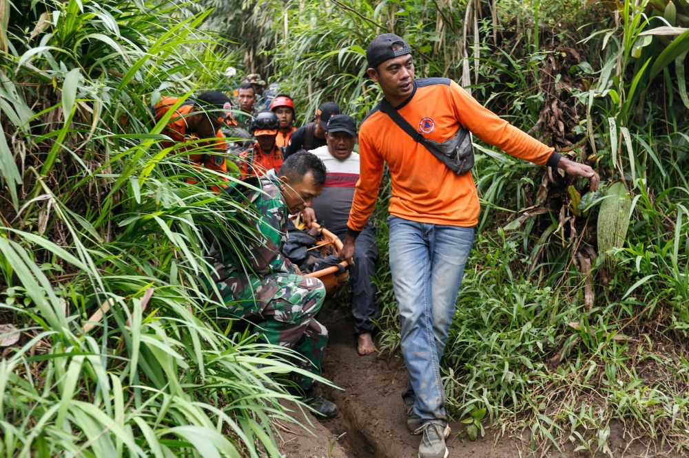 Rescuers carry away a victim after the eruption of Mount Marapi in Agam, West Sumatra, on December 4, 2023. — AFP pic