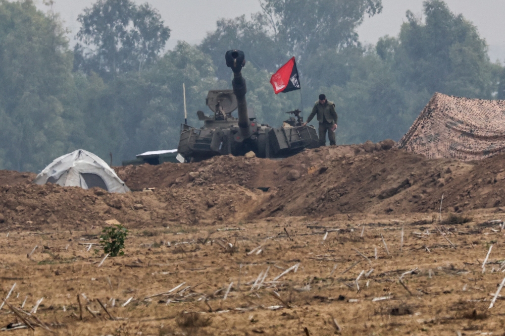 An Israeli soldier stands next to an artillery unit at the border with Gaza, amid the ongoing conflict between Israel and the Palestinian group Hamas, as seen from southern Israel, December 5, 2023. ― Reuters pic