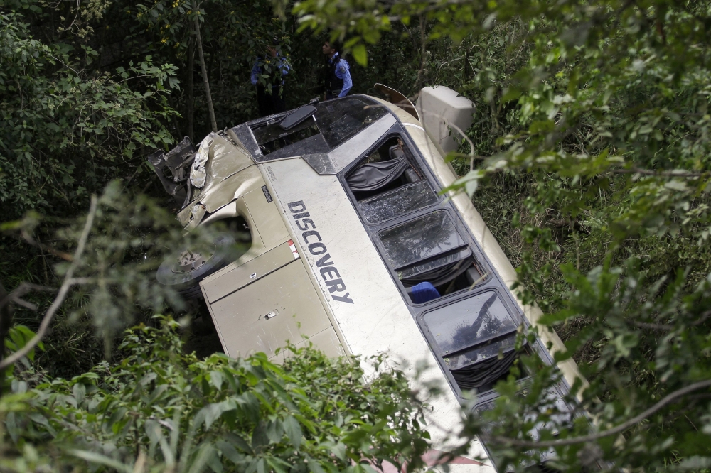 Police officers stand next to the wreckage of a bus, which skidded off a highway and fell into a ravine, leaving some passengers dead and several injured, on the outskirts of Tegucigalpa, Honduras December 5, 2023. ― Reuters pic