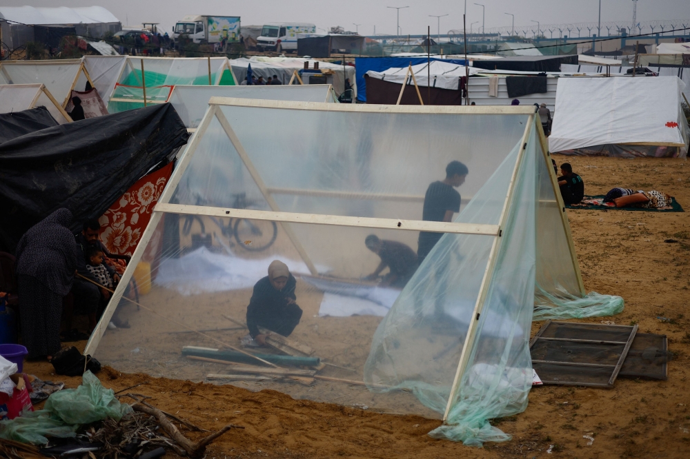 People build a makeshift shelter in a new camp sheltering displaced Palestinians who fled their houses due to Israeli strikes, amid the ongoing conflict between Israel and Hamas, in Rafah in the southern Gaza Strip, December 5, 2023. ― Reuters pic
