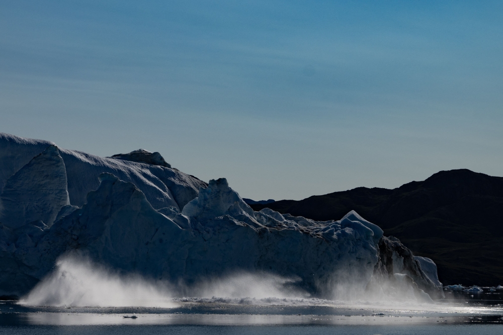 Pieces of a melting iceberg collapse into the sea in Scoresby Fjord, Greenland August 15, 2023. This year will be the hottest in recorded history after an ‘extraordinary’ November became the sixth record-breaking month in row, Europe's climate monitor said on December 6, 2023, piling pressure on nations at the COP28 talks to act on climate change. — AFP pic