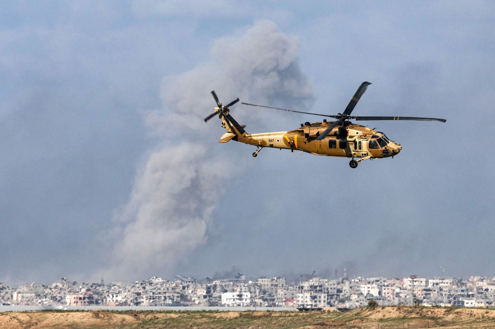 A picture taken from southern Israel near the border with the Gaza Strip on December 6, 2023, shows a Black Hawk military transport helicopter flying near the border with the Palestinian territory amid continuing battles between Israel and Hamas. — AFP pic 