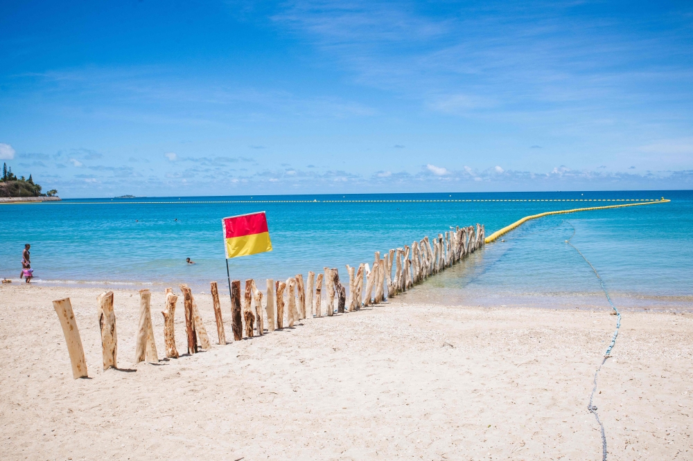 A red and yellow flag delimits the perimeter of supervised swimming area protected by a newly-installed maritime net barrier to prevent shark attacks at a beach along the Baie des Citrons bay in Noumea, New Caledonia. . — AFP pic