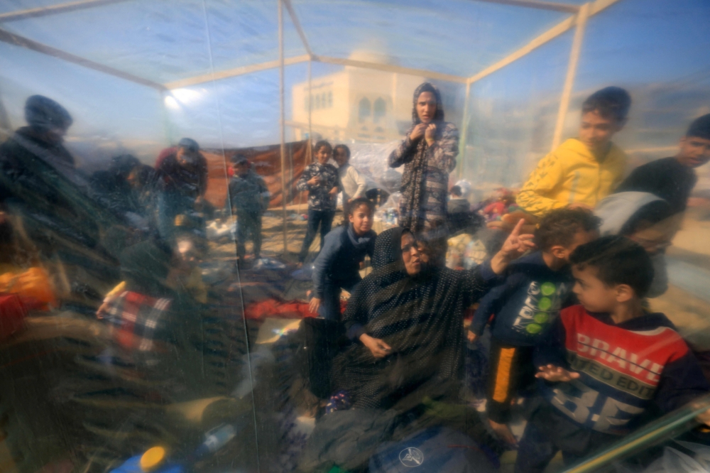 A plastic sheet rigged up as a tent, branches gathered from here and there to make a fire — at the southern tip of Gaza, displaced Palestinians are settling in as best they can. — AFP pic