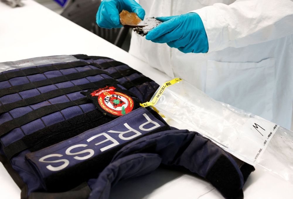 Erik Kroon of the Netherlands Organisation for Applied Scientific Research (TNO) shows the flak jacket of Agence France-Presse (AFP) photographer Christina Assi and metal fragments provided by Reuters for analysis into the killing of Reuters visuals journalist Issam Abdallah on October 13, 2023 in southern Lebanon, in The Hague December 6, 2023. — Reuters pic