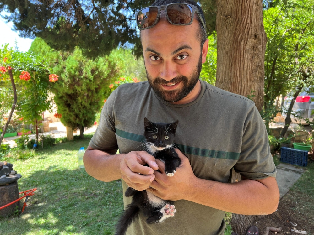 This picture provided courtesy of Reuters shows Reuters' journalist Issam Abdallah holding a kitten while posing for a picture in Saaideh, Lebanon, on July 4, 2023. An AFP investigation released on December 7, 2023 and carried out jointly with the Airwars NGO points to an Israeli-made 120mm tank round being used in the double strike. — AFP pic
